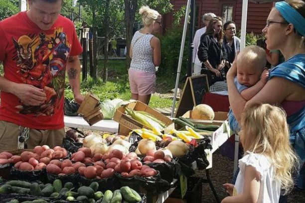 a group of people sitting at a fruit stand