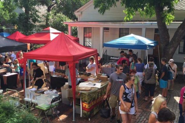 a group of people sitting at a table with an umbrella