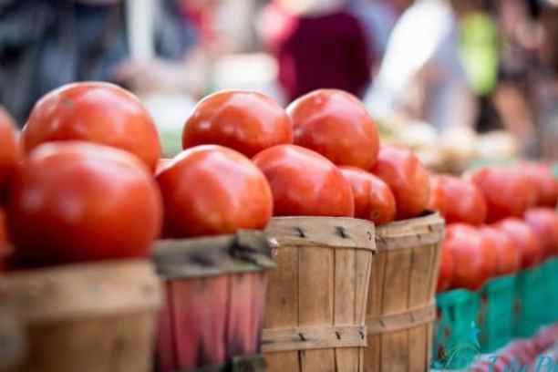 a group of oranges stacked on top of a wooden table